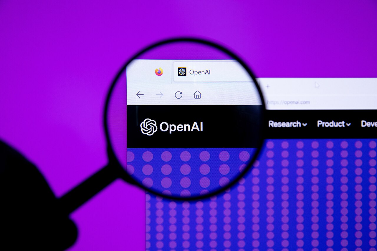 OpenAI logo under a magnifying glass, illustrating investor scrutiny of the OpenAI IPO delay
